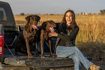 Rice dogs and their owner sitting in truck bed