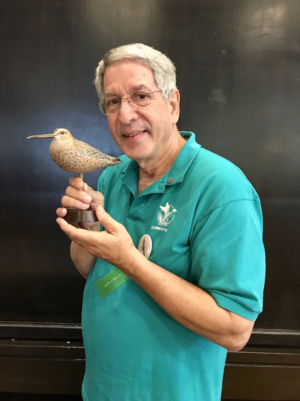 artist holding bird sculpture