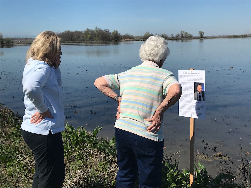 women reading dedication sign