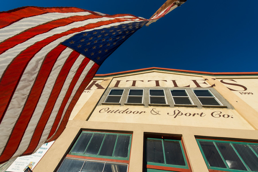 american flag flying outside old storefront