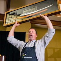 Circle of Life Sushi rolling contest winner holding samurai sword trophy