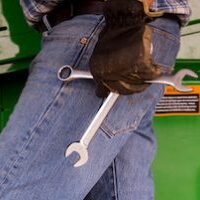 farmer walking and holding tools